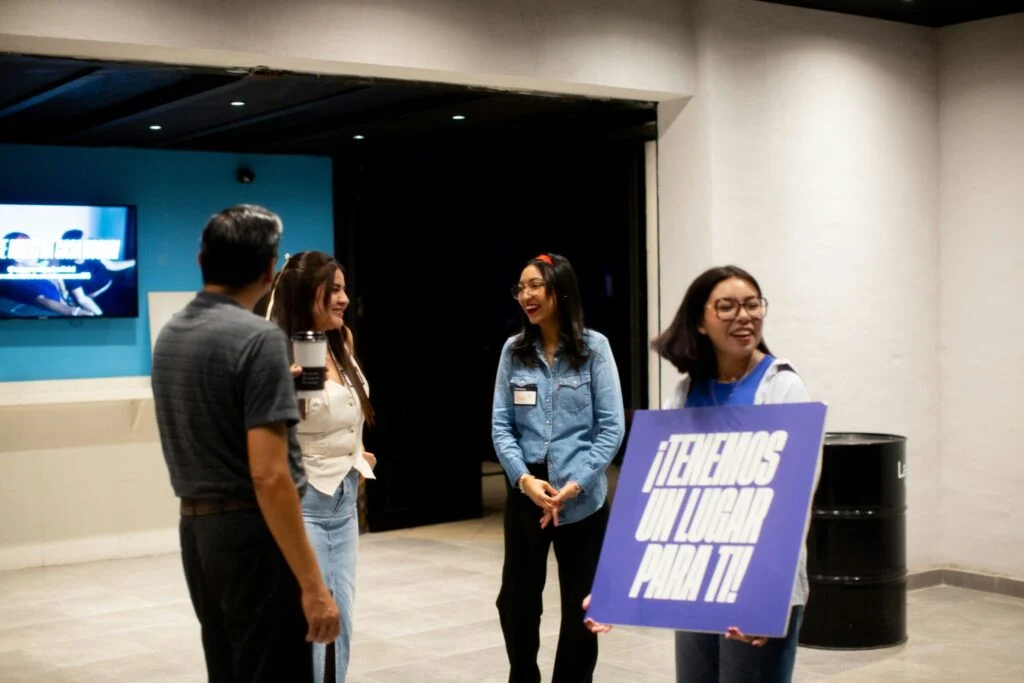 Young adults welcoming guests in the church lobby