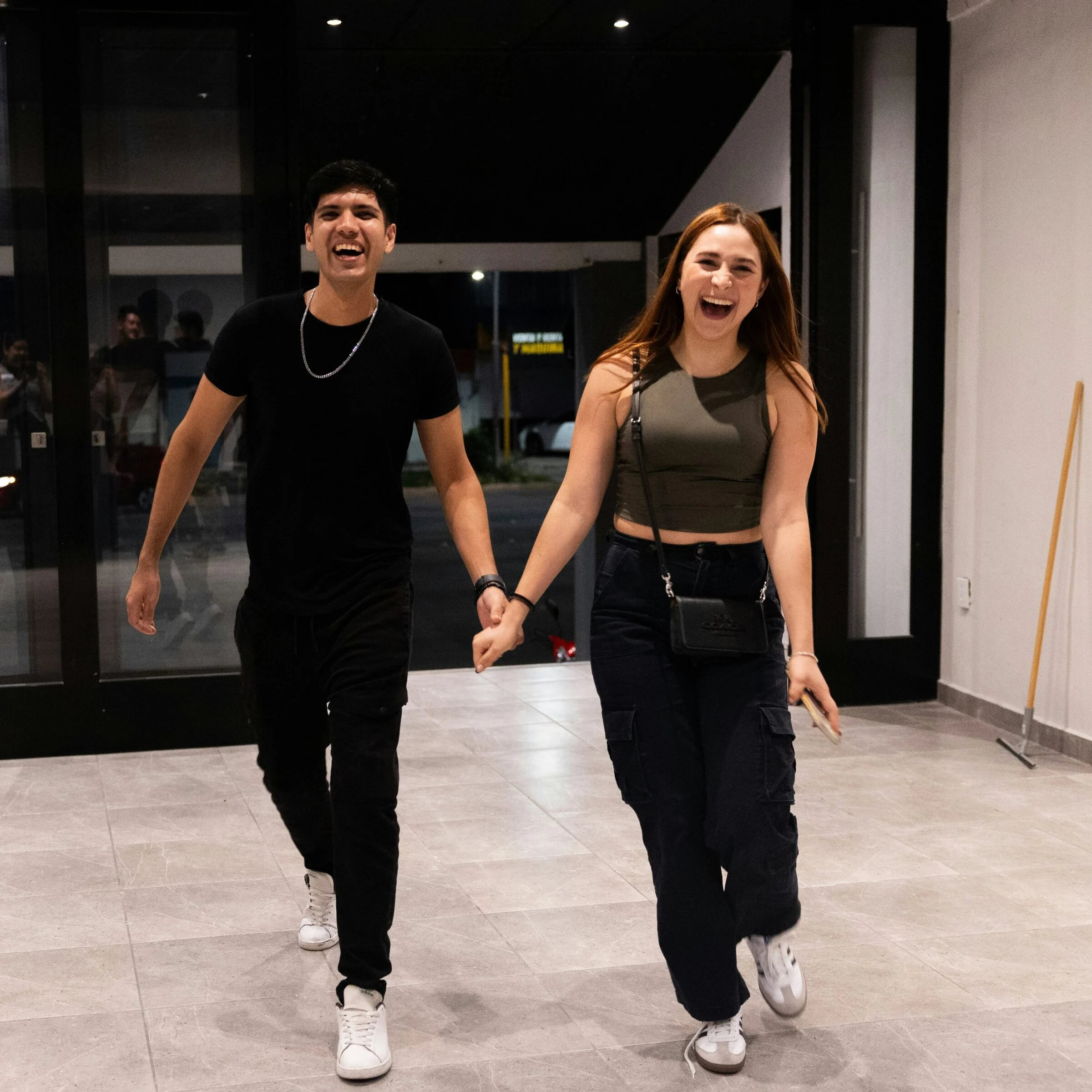 A smiling couple walking into church hand in hand