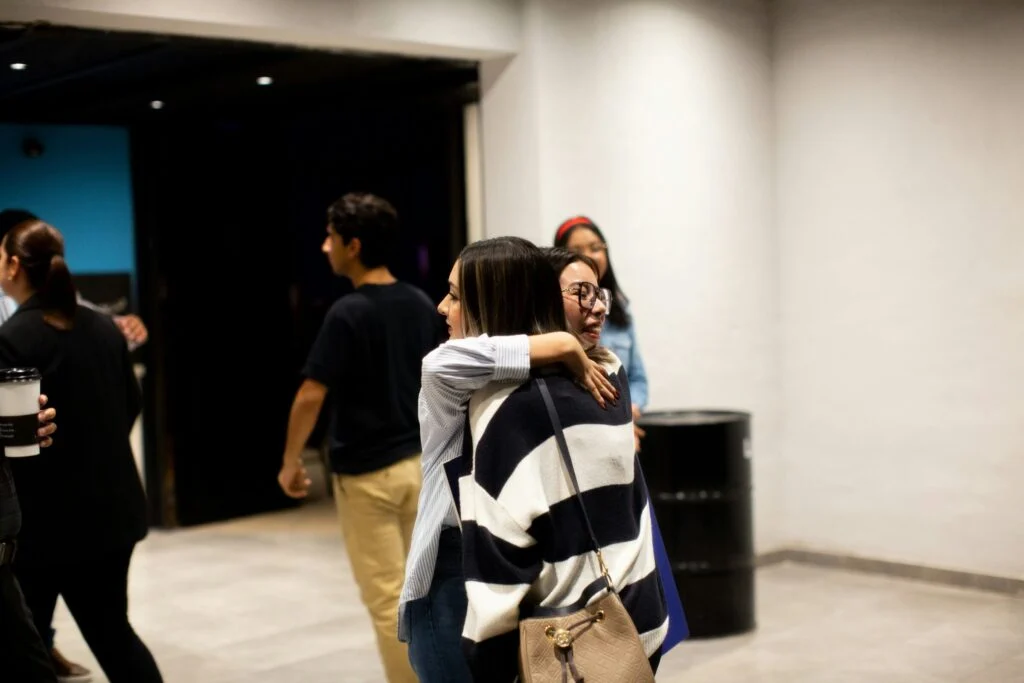 Two friends sharing a welcome hug in the church lobby