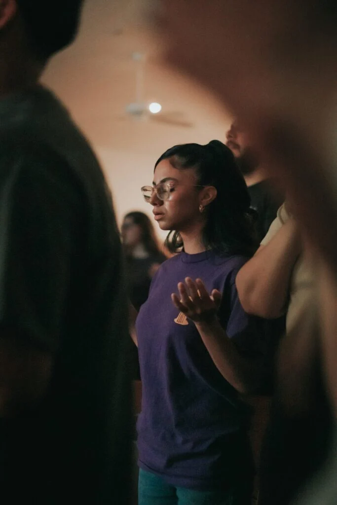 Worshippers with raised hands during a service at Eden Church