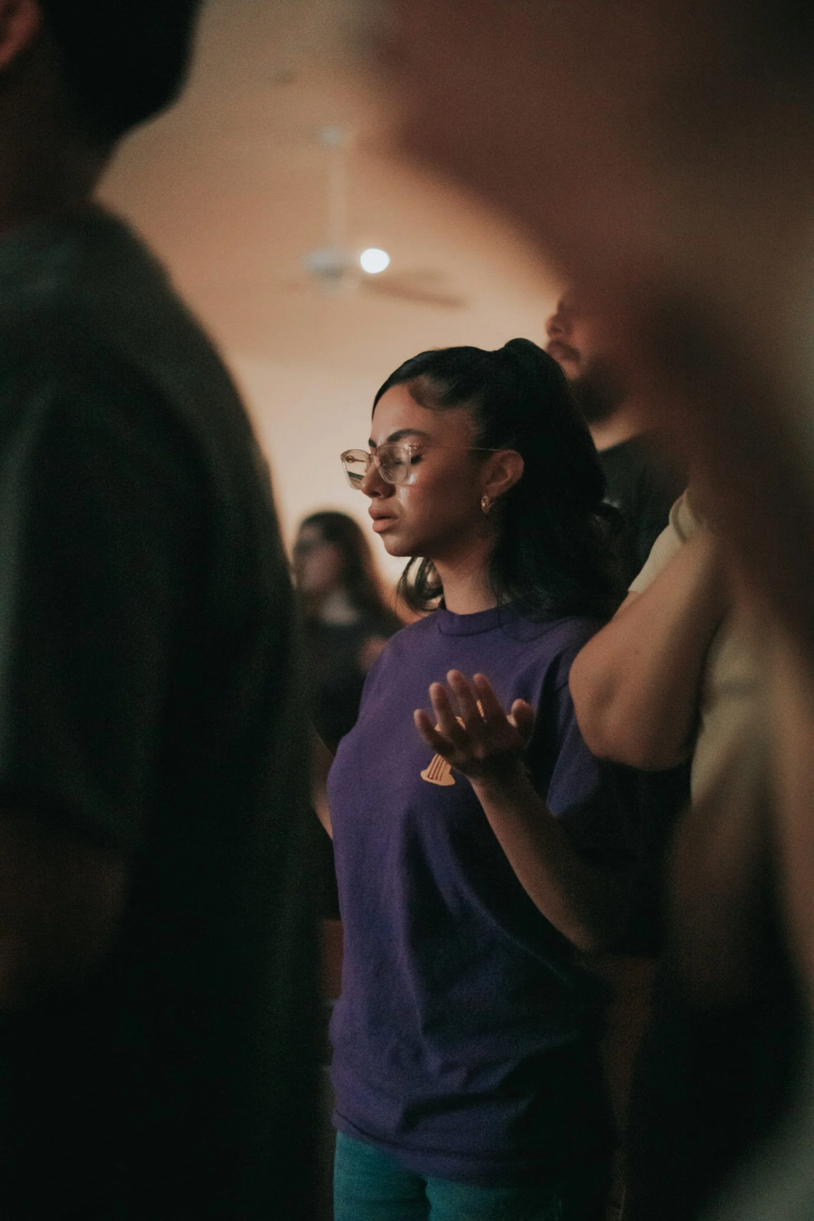 Worshippers with raised hands during a service at Eden Church