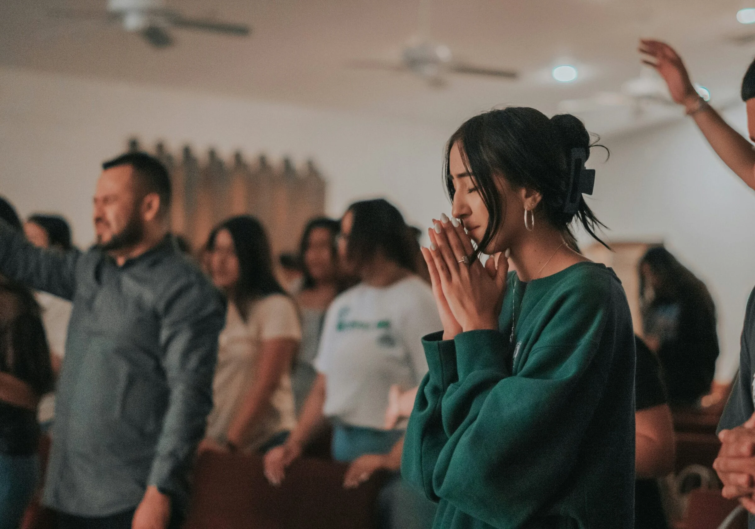 Worshippers singing and praying together during a Sunday service